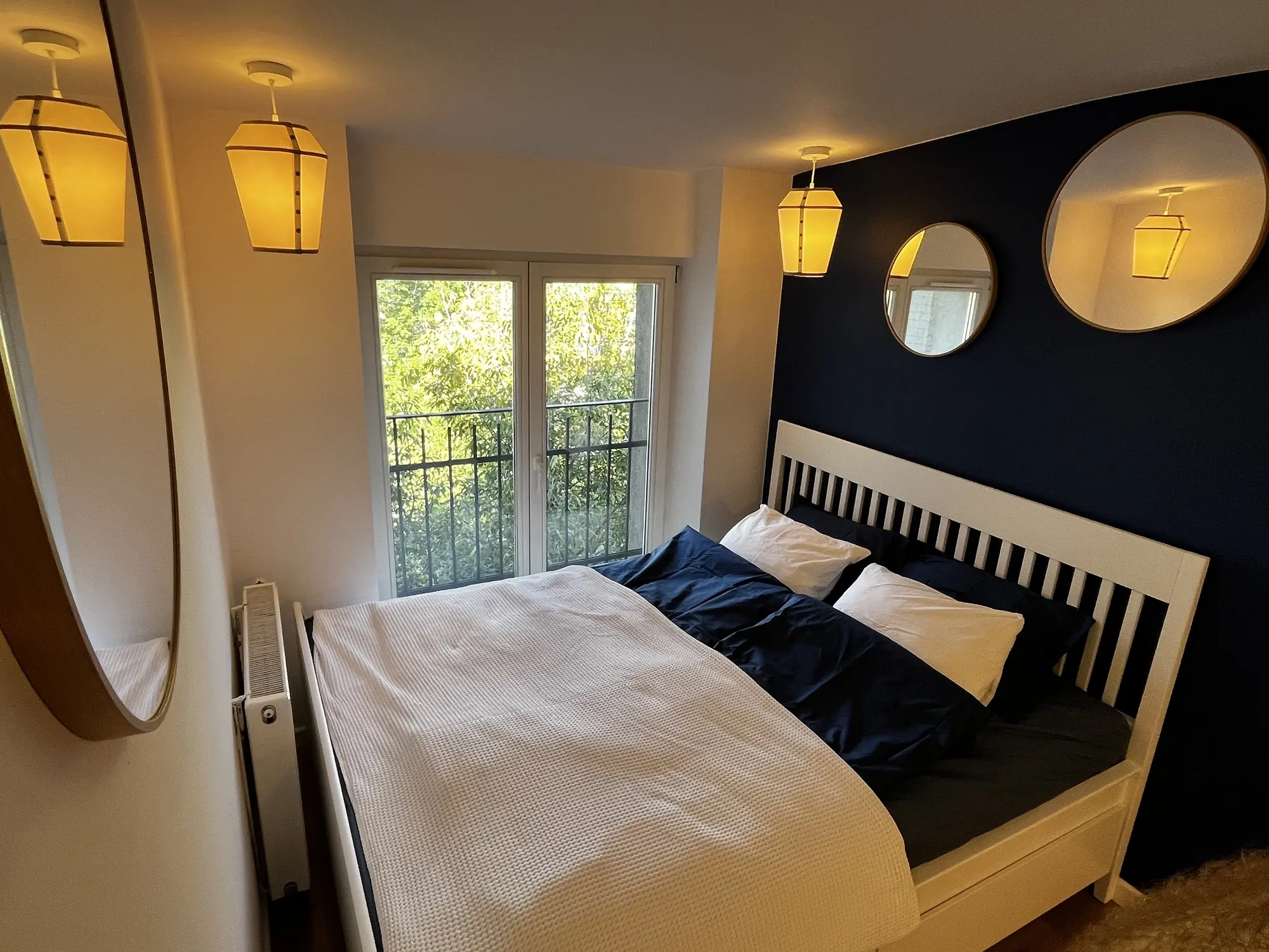 Topolowa Nest bedroom with warm lantern lighting and a navy accent wall